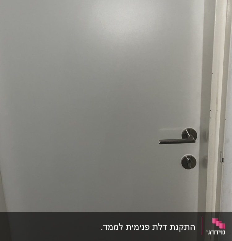 דלת לבנה עם ידית מתכת כסופה ומנעול